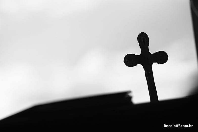 Silhueta de uma cruz recortada contra o céu claro