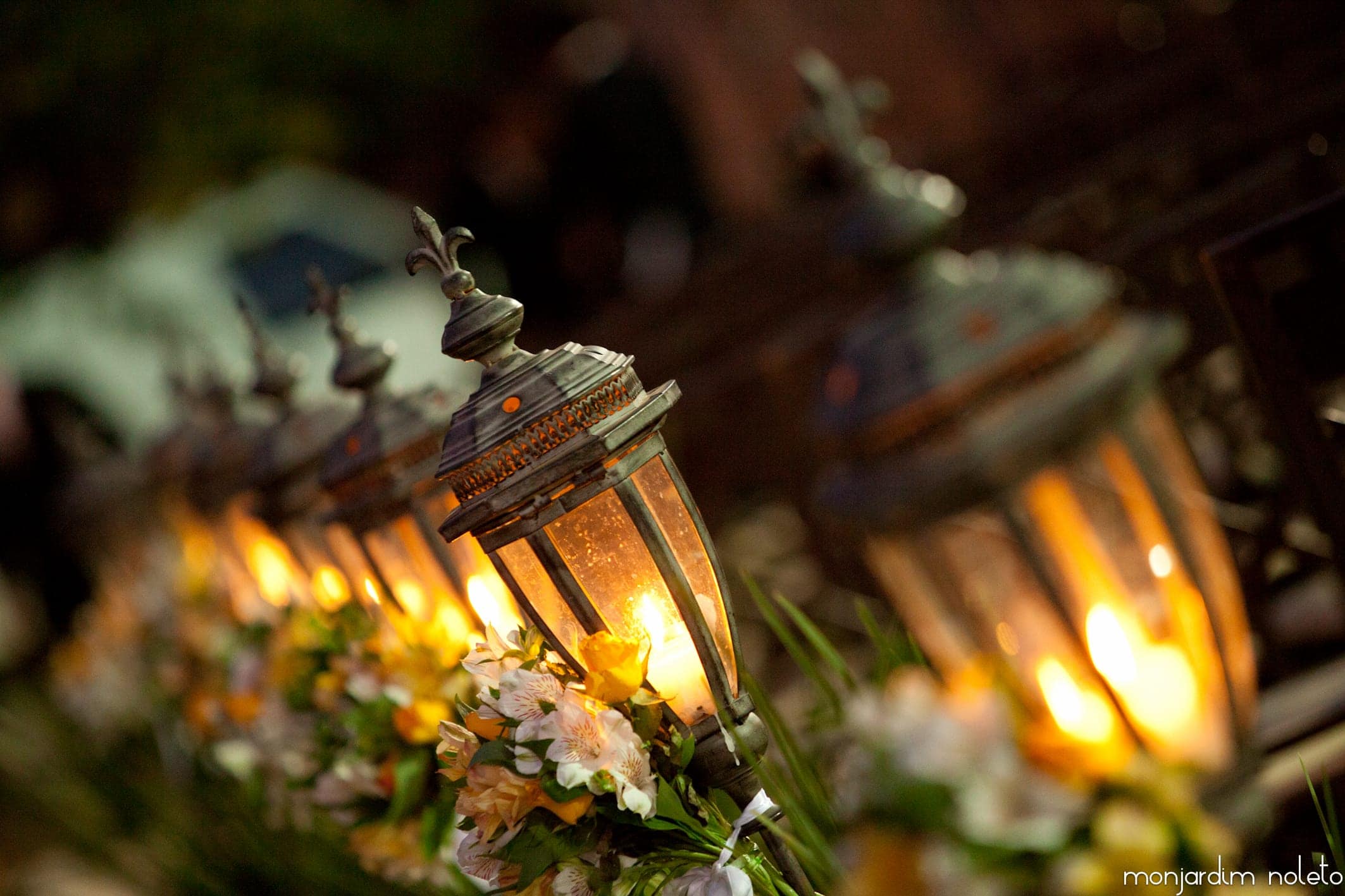 Lanternas e flores compondo o centro de mesa, em luz quente