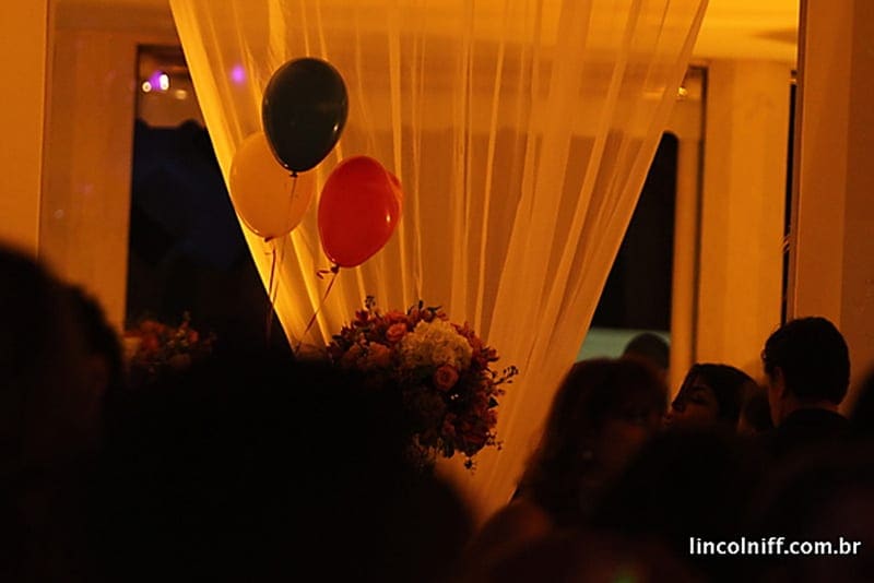 Balões e tenda iluminada durante festa à noite na área externa