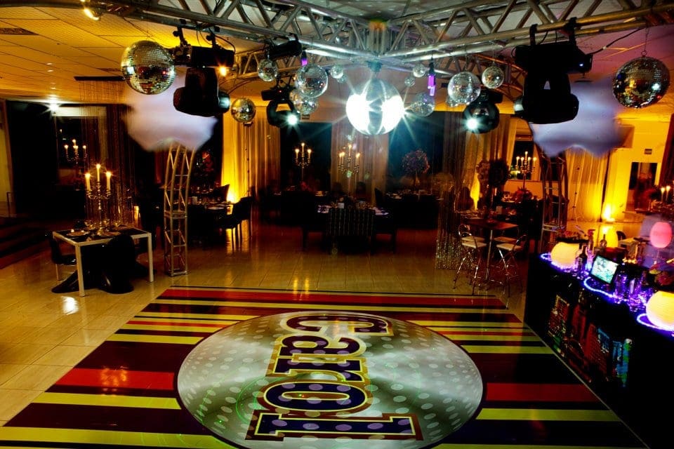 Pista de dança do salão iluminada, com globos de espelho e piso personalizado